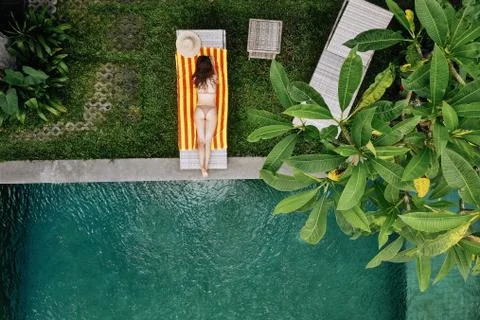 Top view of unrecognizable slim young woman in beige bikini relaxing and sunb Stock Photos