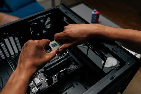 Top view of unrecognizable technician inserting processor into desktop Stock Photos
