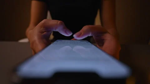 Top view of unrecognizable woman using typing smartphone in dark room, browsing Stock Footage 295638504