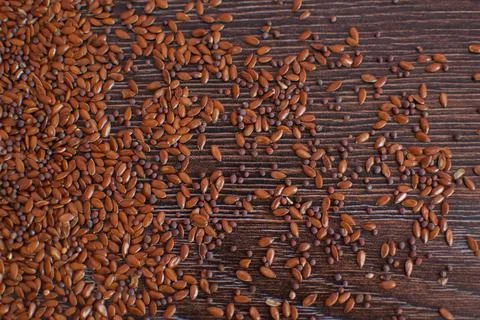 Top view of unsorted flax seeds on dark wooden table, seasonings for food Stock Photos