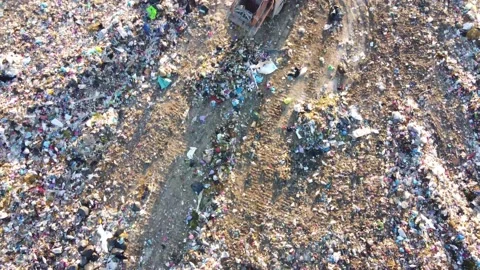 Top view of unsorted landfill. Many seagulls fly over the garbage. Garbage truck Stock Footage 162618430