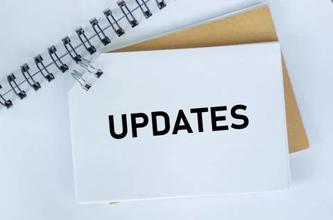 Top view of Updates text on white notepad. Business update concept Foto stock