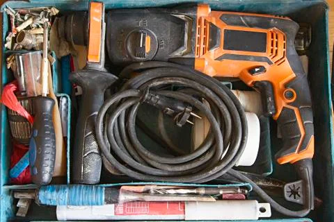 Top view of used worker's tool box, electric drill, screwdriver and screws Stock Photos