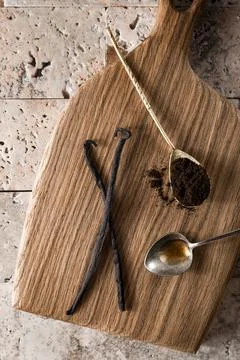 Top view of vanilla beans, extract and powder on a wooden kitchen board. Stock-Fotos