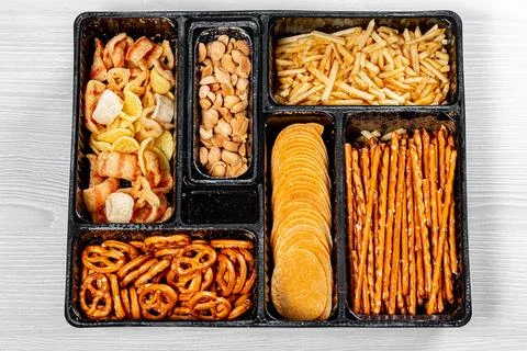 Top view of various beer snacks small pretzels, peanuts, potato chips Stock Photos