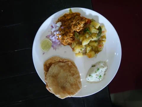 A top view of various curries with breads onion and lime on a plate. Stock Photos
