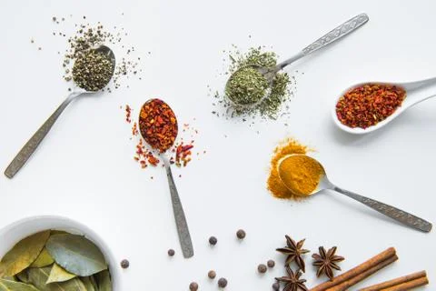 Top view of various dried aromatic spices in metal and ceramic spoons Stock Photos