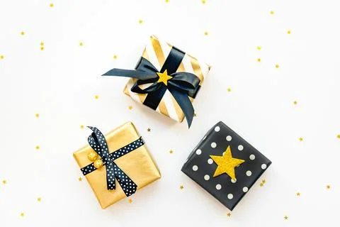 Top view of various gift boxes over star shaped golden sequins white backgr.. Stock Photos