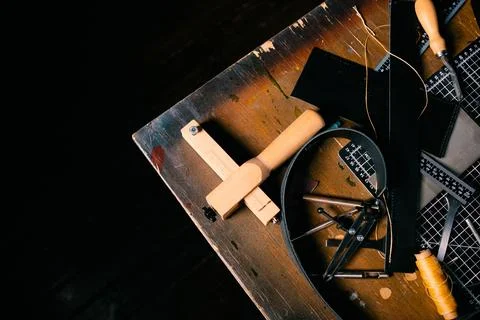 Top view of various leatherworking tools on piece of genuine leather, copy space Stock Photos