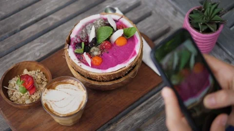 Top view of vegan breakfast of smoothie coconut bowl served on wooden board with Stock Footage 146363549