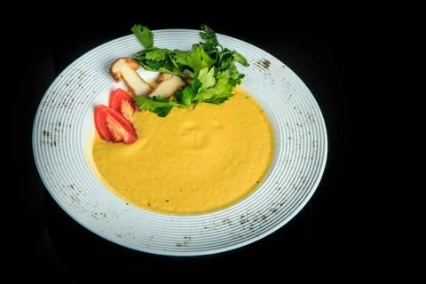 Top view vegetable cream soup decorated with mushrooms, tomatoes, and parsley Stock Photos