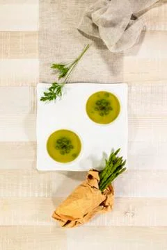 Top view of a vegetable soup double dish with parsley and fresh asparagus in  Stock Photos