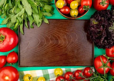 Top view of vegetables as green mint leaves basil tomato around empty tray .. Stock Photos