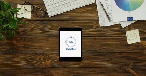 Top view on the vertical black tablet device updating on its white screen while Stock Footage 95097640