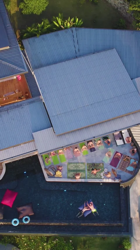 Top view vertical Drone shot of People at pool villa sitting and meditate near Stock Footage 319889601