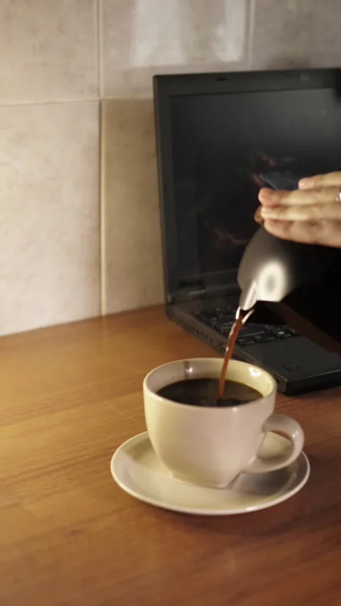 Top view vertical video of pouring hot coffee from moka pot into cup near laptop Stock Footage 344058031