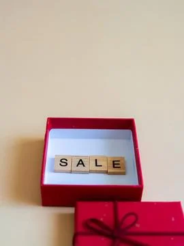 Top view of vibrant red gift box surrounded by wooden letters that spell ou.. Stock Photos