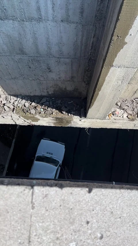 Top view. View from above through gap in concrete wall onto cars on road Stock Footage 308923417