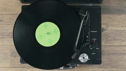 Top view of vinyl on record player on wooden table and green label Stock Footage 218630290
