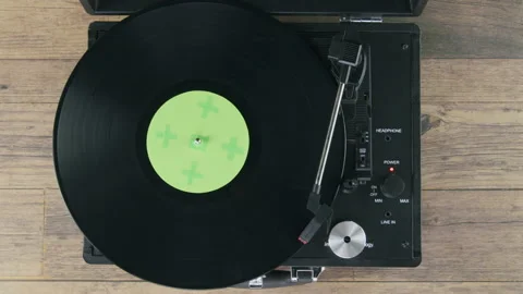 Top view of vinyl on record player on wooden table green label Stock Footage 218630326