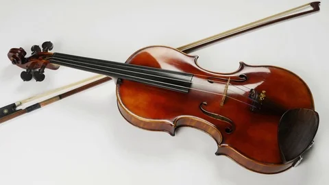 Top view of the violin and a bow near it. Bow under the violin Stock Footage 77021787
