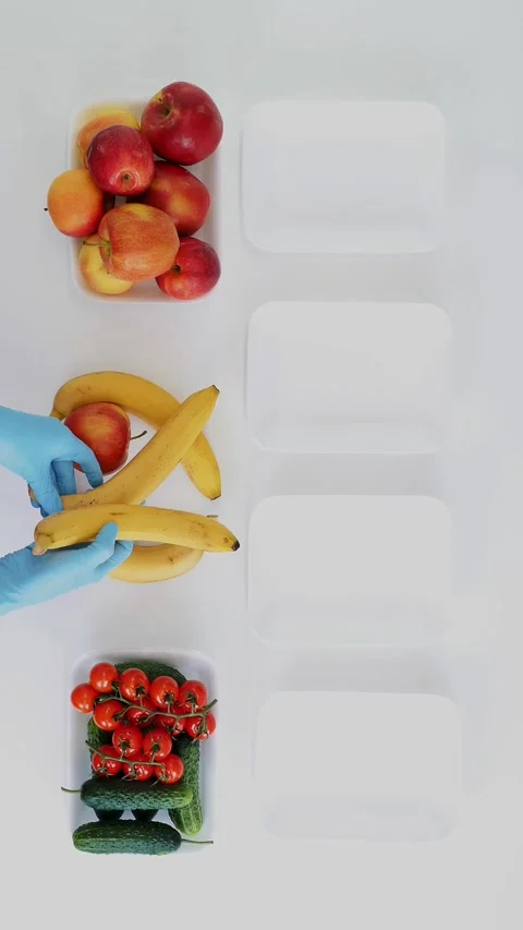Top view. Volunteer in protective gloves packs grocery, puts fruits and Stock Footage 323438383