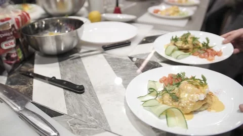 Top view the waiter serves plates of food with poached egg, salmon and cucumber. Stock Footage 171462797