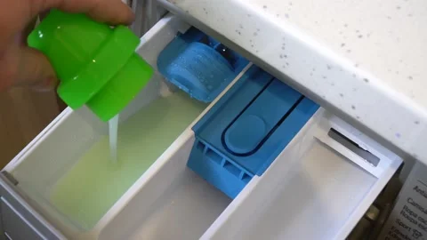 Top view of washing machine. Hand pours powder into the washing machine. Stock Footage 149576949