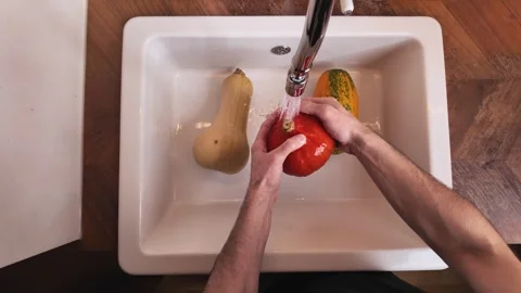 Top view washing pumpkins in kitchen sink under water Video stock 330898801