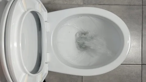 TOP VIEW: Water flows in a white toilet Stock Footage 90240005