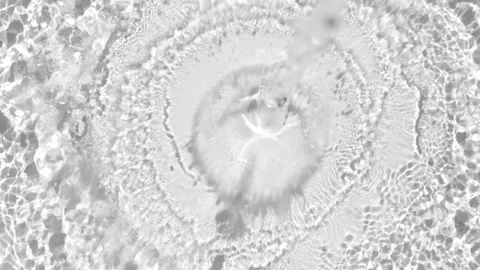 Top view of water jet falling into a calm pool, creating concentric circles and Stock Footage 312124425