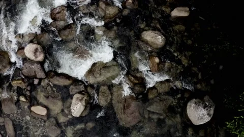 Top view of a waterbed full of rocks in a coloration close to black and white Vidéo 151277804