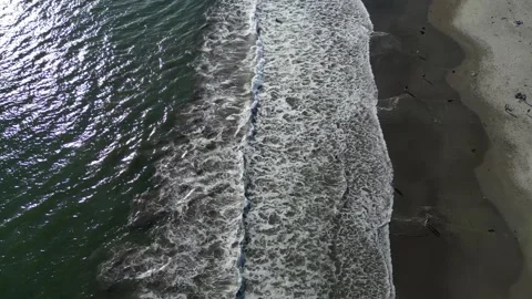 Top view of the wave rolling on the beach and people enjoying it Stock Footage 266064062