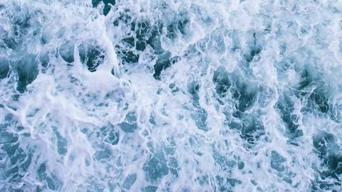 Top view with waves and bubbles of ocean blue water surface. 库存照片