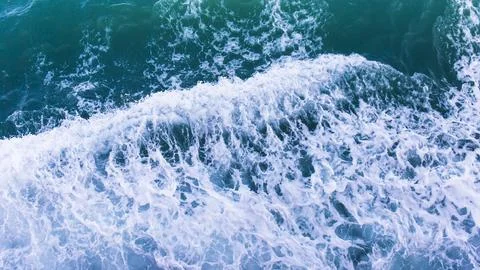 Top view with waves and bubbles of ocean blue water surface. Stock Photos