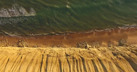 The top view of the waves that beat against the high sandy beach in day time Stock Footage 79811105