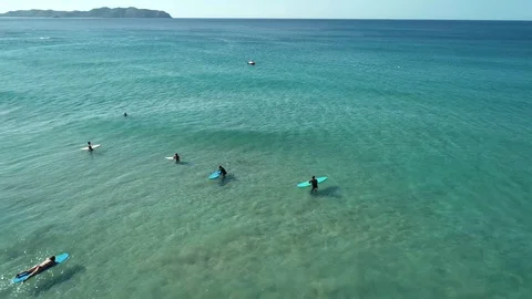 Top view of waves break on tropical white sand beach and surfers with surfing Stock Footage 103574916