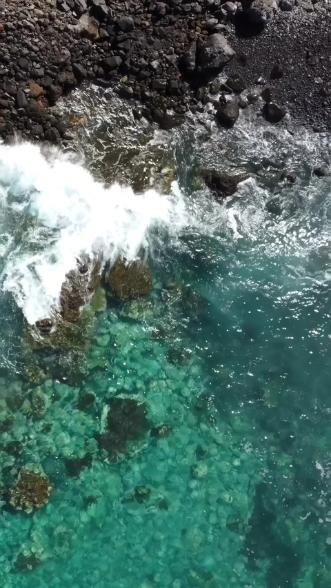 Top view of waves breaking on the stone and rock shore and transparent water Stock Footage 280025951
