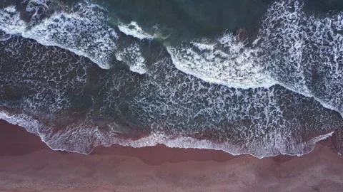 Top view of waves crashing at the beach. Stockbeeldmateriaal 258303933