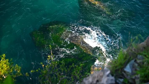 Top view of waves hitting by rocks. Beautiful ocean waves slow motion. Stock Footage 128898423
