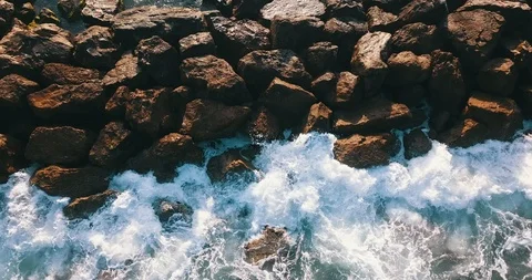 Top view of waves hitting stone breakwater at sea Stock Footage 105497320
