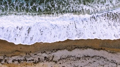Top view of the waves of the sea surf with white foam on the yellow sand Stock Footage 105747971