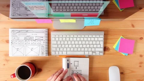 Top view. Webmaster draws the future layout of the web pages in the sketch book. Vídeo Stock 72427855