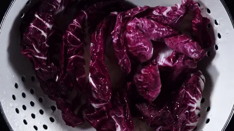 Top view of wet red salad radicchio, rotating clockwise in white strainer Stock Footage 76964706