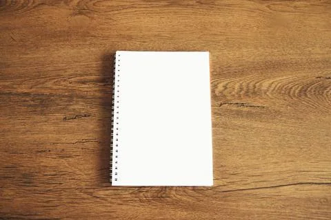 Top view of white blank notebook on wooden table Stock Photos
