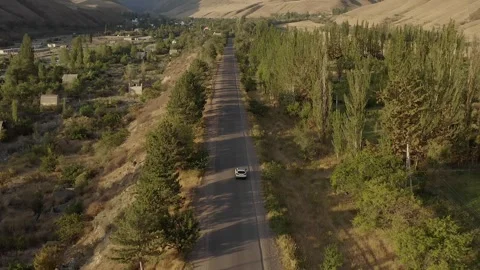 Top view of a white car moving along an asphalt road in the mountains Video stock 259792591
