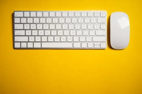 Top view of white computer keyboard and mouse on yellow desk Stock Photos