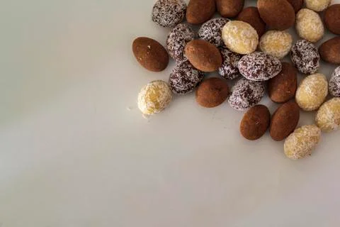 Top view of white, dark and cocoa Chocolate almonds on white table Stock Photos