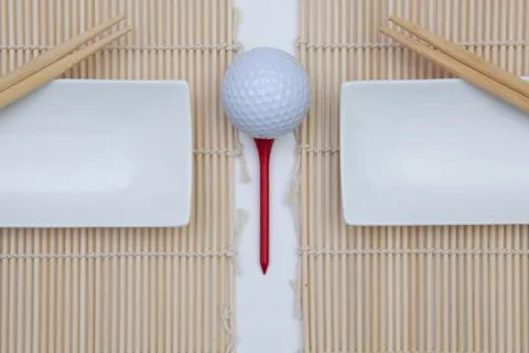 Top View Of White Empty Sushi Plates With Bamboo Chopsticks and Golf Ball. 库存照片