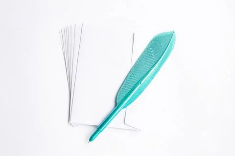 Top view of white envelopes with blue plastic feather pen on white background Stock Photos